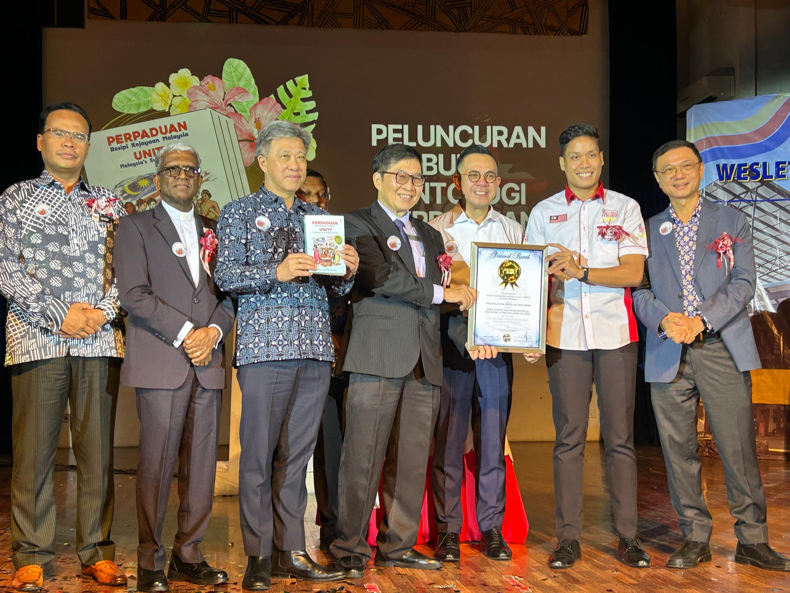 Wesley Methodist School Kuala Lumpur (International) Breaks Record with Unity Anthology, Enters Malaysia Book of Records 2 WMSKLI representatives receiving the official Malaysia Book of Records certificate on stage during the celebration event